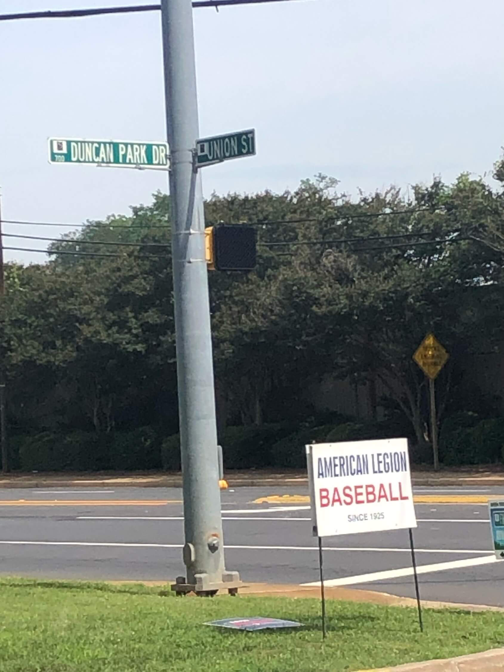 Street signs at the corner of Duncan Park Drive and Union Street in Spartanburg, with an American Legion Baseball "Since 1925" yard sign in the foreground.